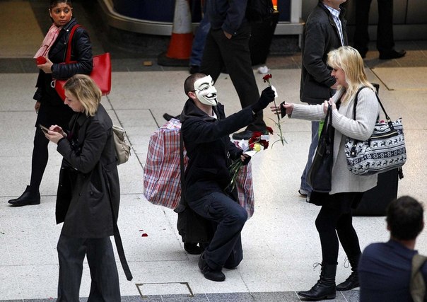 Чтобы отметить Первое мая, активист Occupy London дарит цветы пассажирам на центральном вокзале Лондона, Великобритания. 
