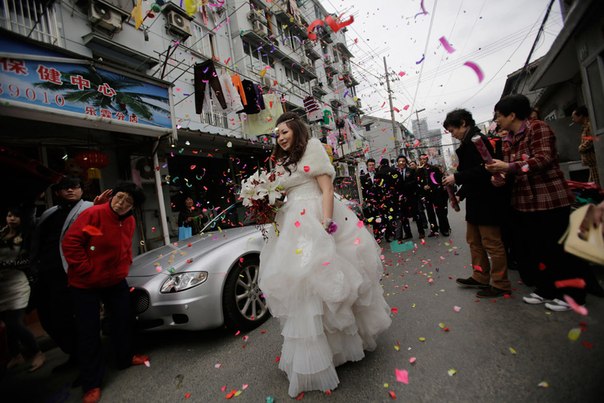 Соседи благословляют невесту на улице в Шанхае, Китай.