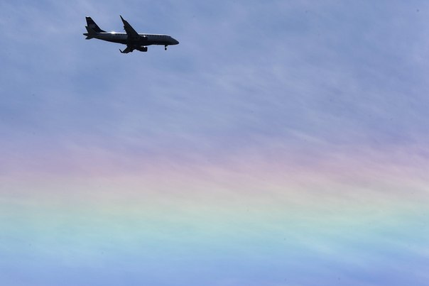 Самолет авиакомпании US Airways пролетает над радугой в Филадельфии, штат Пенсильвания, 14 мая 2013 года.