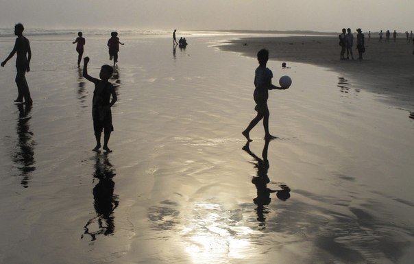 Люди отдыхают на пляже на берегу Бенгальского залива в Ситуэ, Мьянма, 17 мая 2013 года.