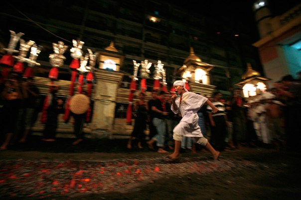 Мусульманин-шиит бежит по горячим углям во время празднования религиозного фестиваля Ашура в Янгоне, Мьянма.