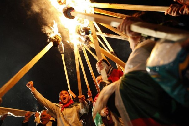 Демонстранты жгут факелы во время акции протеста возле Национального дворца культуры в Софии, Болгария.