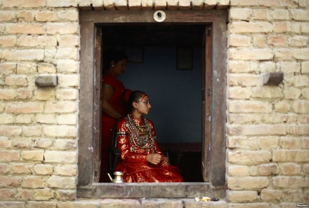 Живая богиня Кумари Самита Баджрачари сидит у окна в своём доме в Лалитпуре, Непал.