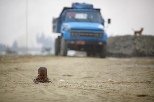 Ребенок играет на дороге недалеко от реки Янгон.