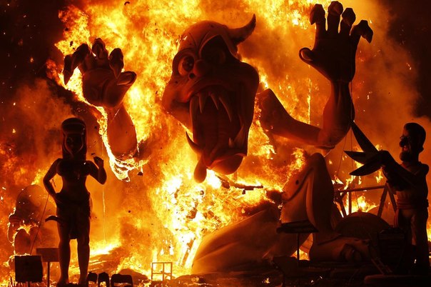 Люди сжигают чучела во время фестиваля Фальяс в Валенсии.