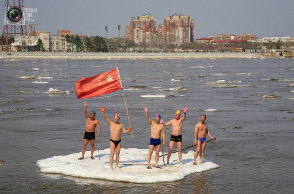 Любители моржевания плывут на дрейфующей льдине по реке Амур в городе Хэйхэ, Китай.