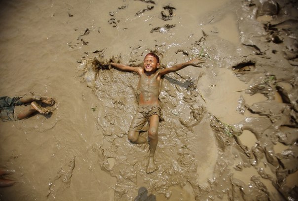 Мальчик играет в грязи на берегу реки Баго в Пегу, Мьянма.