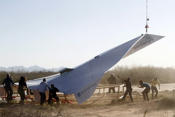Работники готовятся запускать 14-метровый бумажный самолет из музея Pima Air & Space Museum в пустыне в Элое, штат Аризона.
