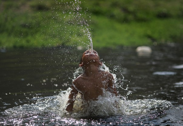 Мальчик купается в реке Багмати в Катманду, Непал.