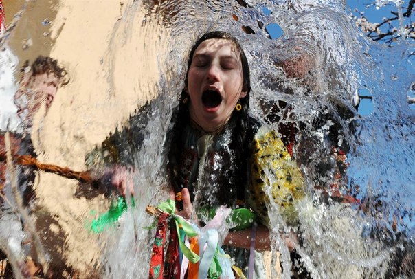 Словаки в народных костюмах выплескивают ведро воды на девушку во время празднования Пасхи в деревне Trencianska Tepla, Словакия, 9 апреля. Мужчины обливают женщин водой и бьют ивовыми прутиками с пожеланиями молодости, силы и красоты.