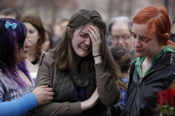 Девушка плачет во время панихиды по жертвам взрывов на Бостонском марафоне, 16 апреля 2013 года.