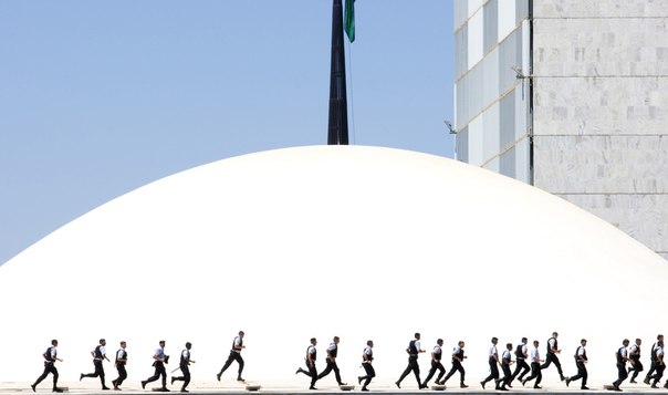 Полицейские бегут через здание Национального Конгресса в Бризилии во время демонстрации против коррупции.