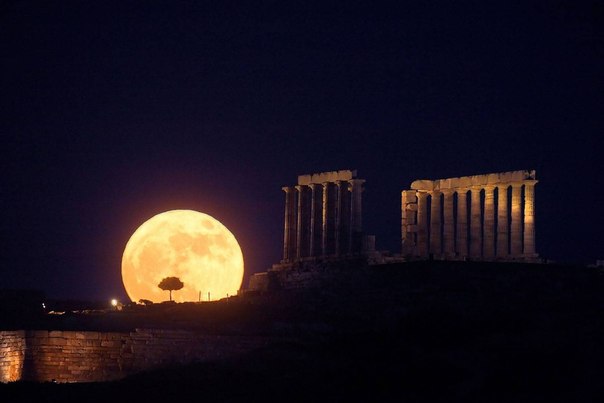 Полная Луна восходит над храмом Посейдона в Акрополе, Греция